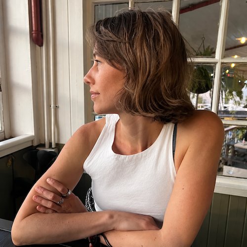 Muriel at a café window, looking to the side